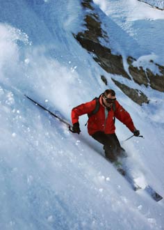 Man skiing off piste on steep mountain