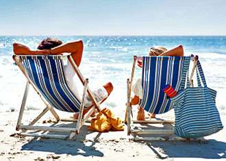 Two people sitting on a beach enjoying perfect trip