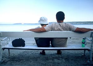 Romantic couple sitting on a bench looking at the sea