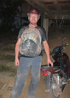 Man standing next to motorcycle driving the Laos Loop