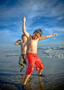 Two young boys dancing on the beach