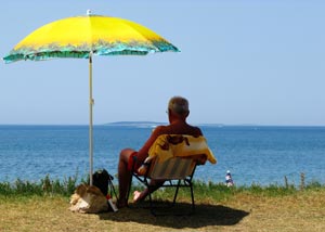Man sitting under sun umbrella