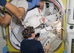 Two astronauts packing luggage in space