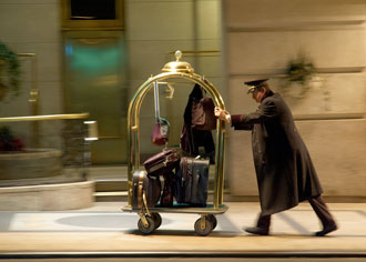 Hotel porter pushing trolley full of luggage